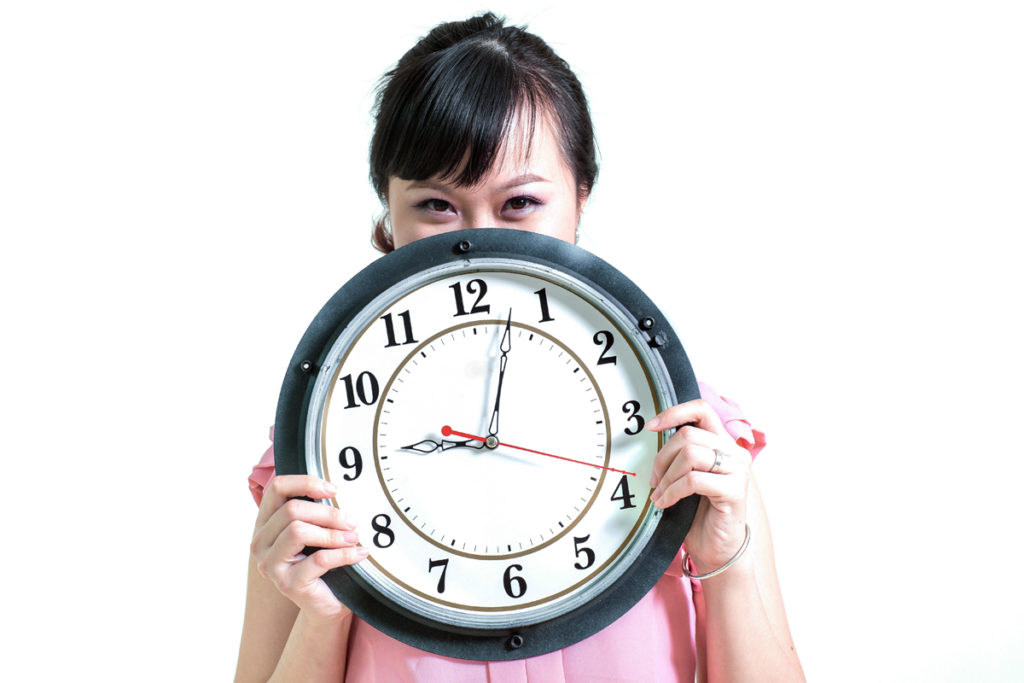 Woman holding clock to expose meal timing myths